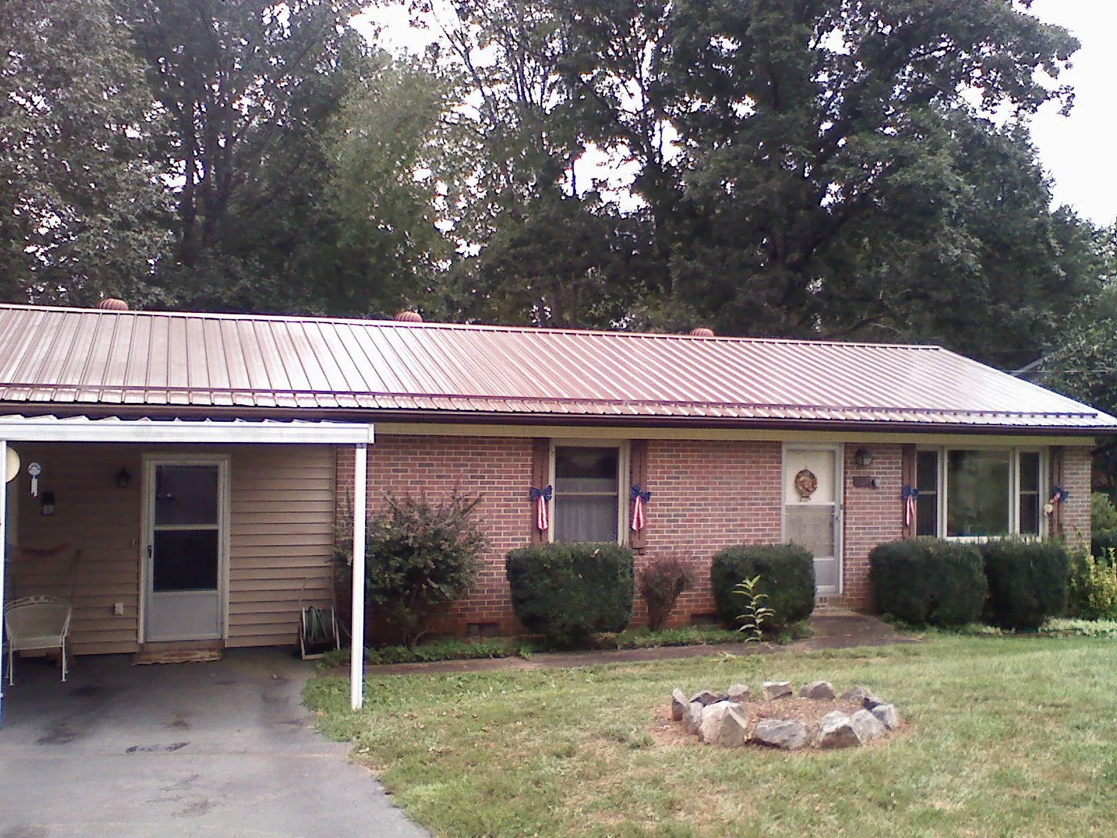 Bronze metal roof and carport on a brick ranch home — Roof Repair work by our crew in Alden